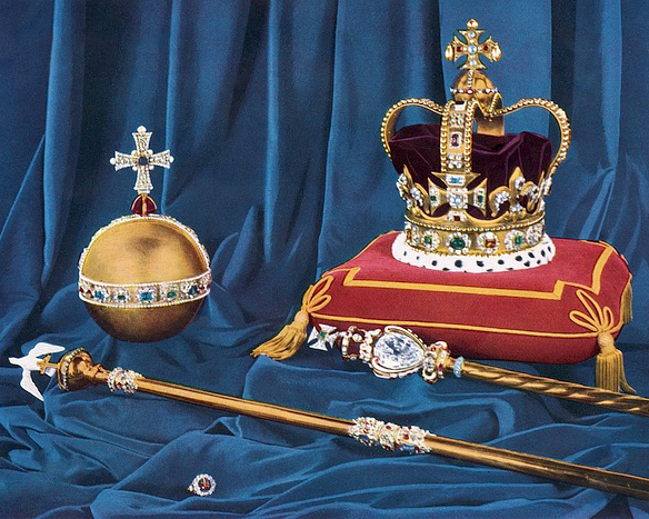Bejeweled crown of the United Kingdom set on a red and gold pillow beside the golden globe, rod, scepter and ring, all on deep blue velvet.
